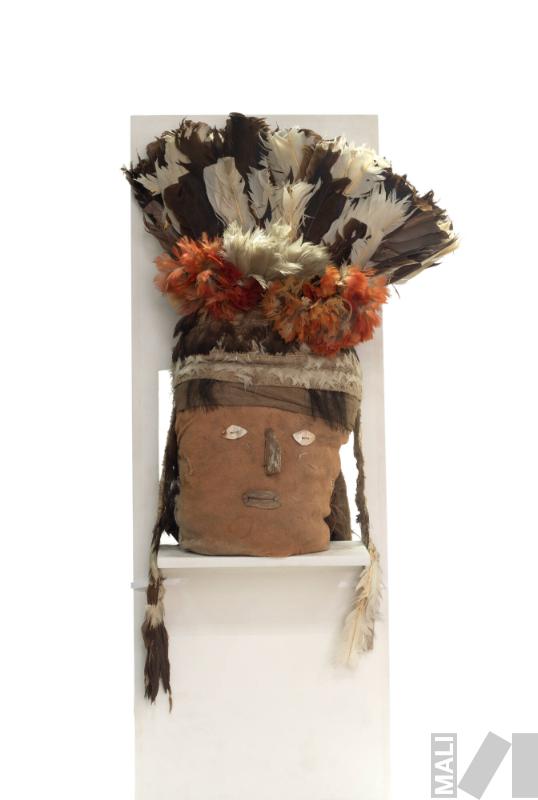 Cabeza de fardo funerario con rostro humano y tocado de
plumas