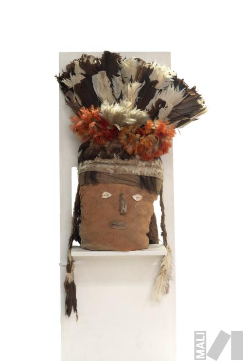 Cabeza de fardo funerario con rostro humano y tocado de
plumas