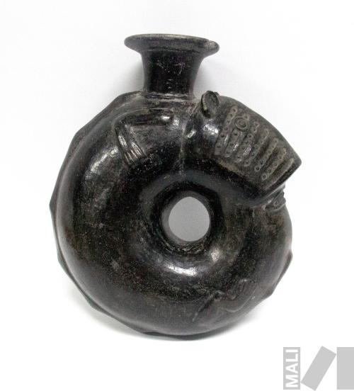 Cántaro que representa a un personaje zoomorfo que se encuentra comiéndose o mordiéndose la
cola