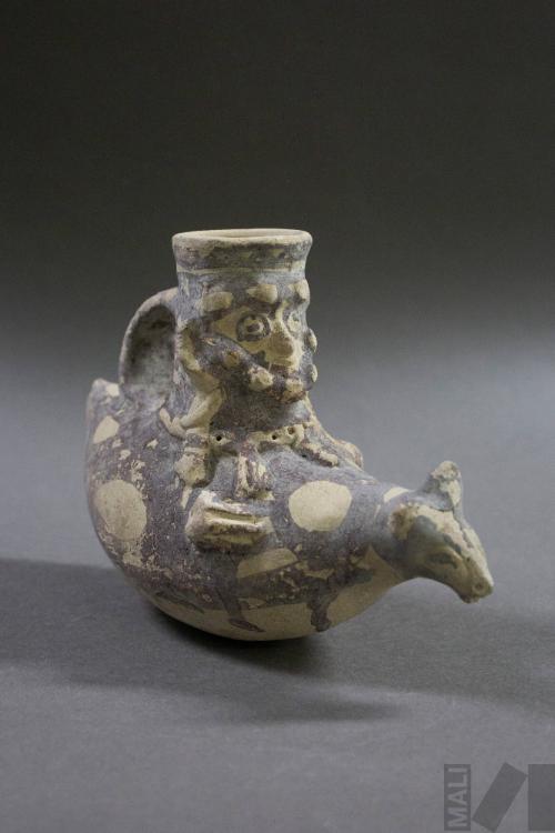 Botella que representa un personaje sentado sobre un camélido